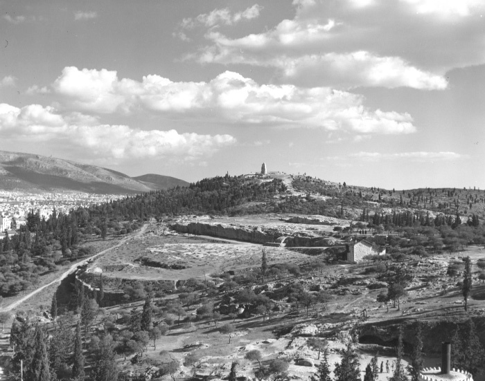 Οι μικρές σπηλιές του λόφου των Νυμφών, μπροστά δεξιά· λήψη από το κτήριο του Αστεροσκοπείου (Αμερικανική Σχολή Κλασικών Σπουδών στην Αθήνα, Φωτογραφικό Αρχείο των Ανασκαφών Αρχαίας Αγοράς, AT 220).