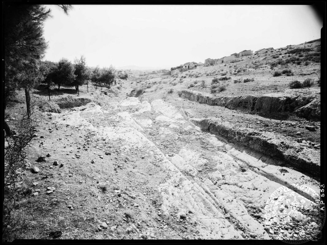 Beyond the ancient wheel ruts the gaze falls on the little dwellings of Asyrmatos (American School of Classical Studies at Athens, Archaeological Photographic Collection, AP 0553).